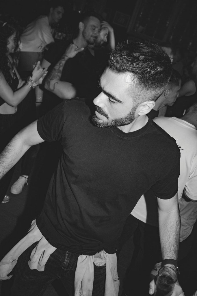 Chico con barba y camiseta negra bailando en la pista de YASS! Party Barcelona